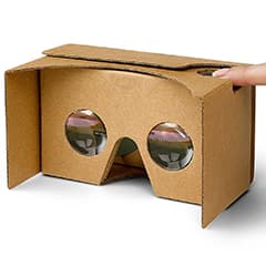 looking through Cardboard VR eye openings with finger pressing smartphone button