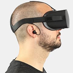 Side portrait of a bearded bald man wearing a black shirt using the oculus rift VR headset